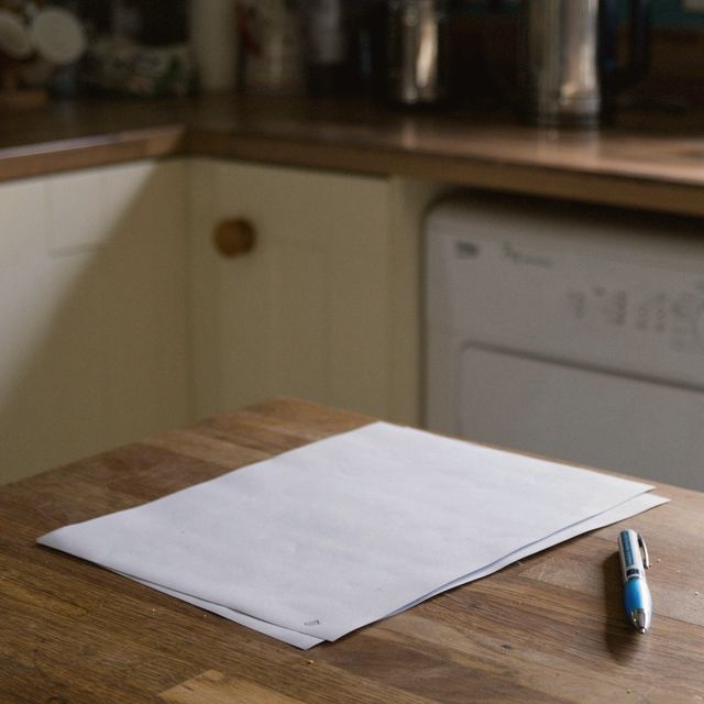 Two printed pages and a pen on a wooden kitchen table